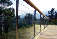 artecbois garde-corps contemporain sur terrasse en meleze structure en tubes inox316 et cables en inox316 avec panneaux de verre securit la rampe est en bois exotique